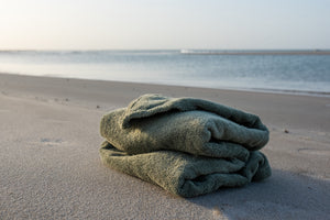 poncho bath organic cotton sage folded on the beach - Atelier Dune