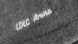 Gros plan sur une broderie LDLC Arena en fil blanc sur poncho éponge gris 