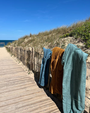 Ponchos de bain en coton bio Atelier Dune suspendus au bord de l'ocean 