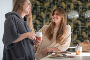 Deux jeunes filles prenant le thé en ponchos graphite et sable - Atelier Dune