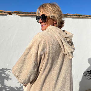 femme souriante avec des lunettes en poncho de bain sable - Atelier Dune