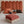 deux ponchos en coton bio terracotta et sable pliés sur un lit - Atelier Dune