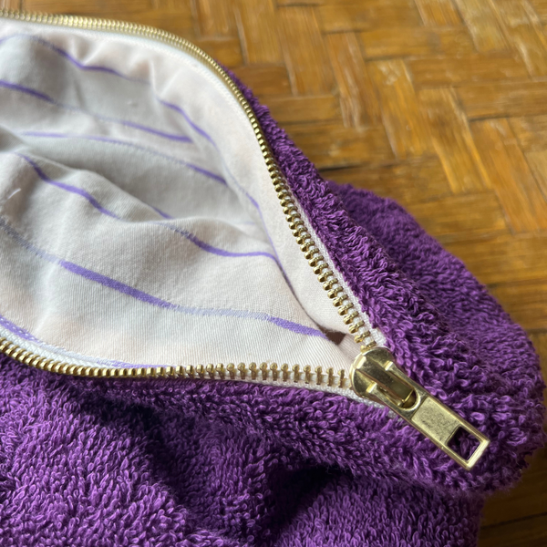 Gros plan sur Trousse ouverte en éponge madeinfrance coloris ultra violet, douce et moelleuse, avec doublure upcyclée rayée - Atelier Dune