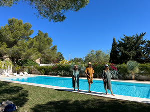 Trois femmes en poncho lagon, caramel et sauge au bord de la piscine - Atelier Dune