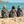 Un groupe de 3 femmes de dos assises au bord de la mer portant un poncho zebre, kaki sauge et graphite - Atelier Dune