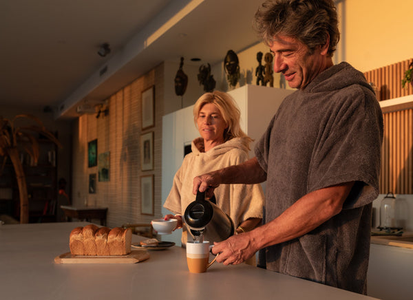 Homme et femme qui boient du café en ponchos en coton bio sable et graphite - Atelier Dune