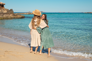 deux jeunes filles riant au bord de la mer en poncho sable et sauge - Atelier Dune