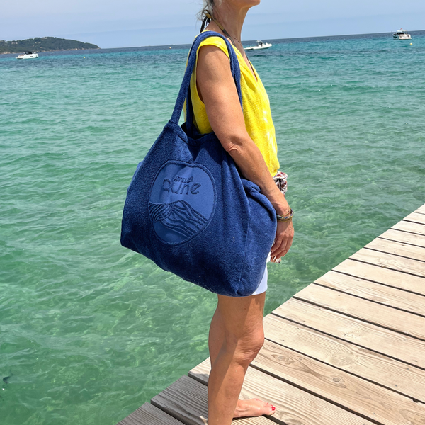 Maxi totebag éponge Bio coloris outremer, porté par une femme debout sur un ponton qui plonge dans la mer - Atelier Dune