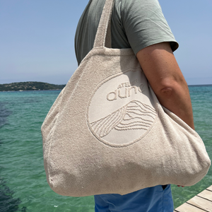 Maxi totebag éponge Bio coloris sable porté à l'épaule par un homme en bord de mer - Atelier Dune