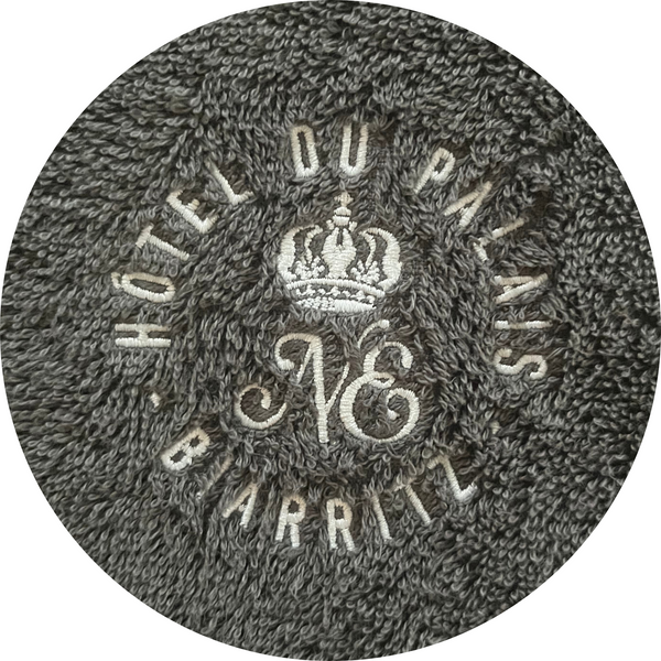 Zoom sur le logo Hôtel du Palais Biarritz  brodé sur un poncho bio graphite - Atelier Dune