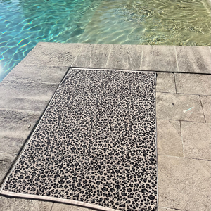 Drap de plage en coton biologique velours leopard au bord de la piscine - Atelier Dune