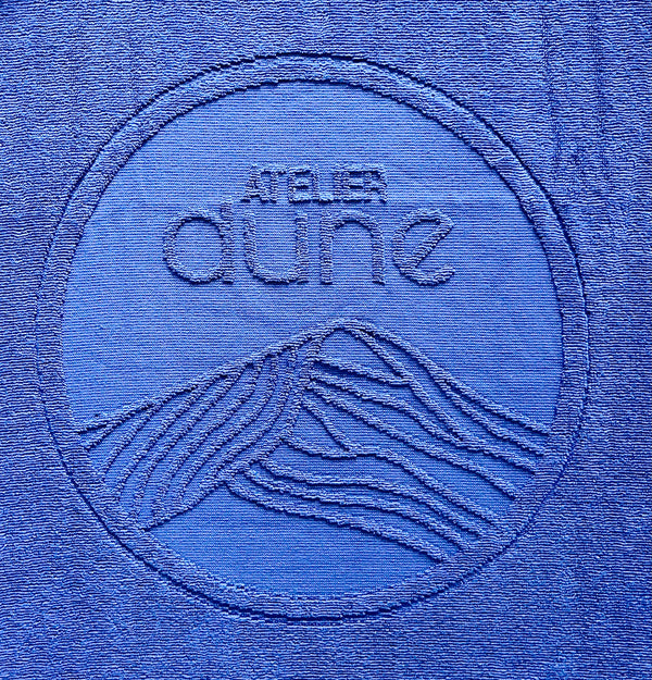 Zoom sur le logo du drap de plage en coton biologique coloris outremer - Atelier Dune