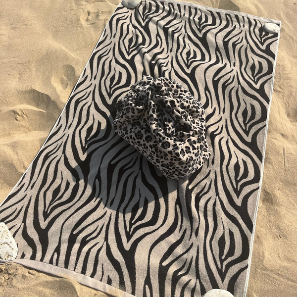 Drap de plage en coton biologique velours zebre pose sur le sable - Atelier Dune