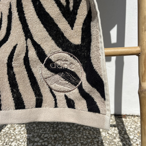 Zoom sur le logo du drap de plage en coton biologique velours zebre - Atelier Dune