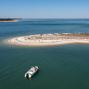 mer avec bateau allant vers une petite ile de sable blanc - atelier dune