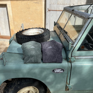 land rover vert avec poncho de bain sauge et graphite plié - atelier dune