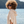Femme souriante au bord de la mer en poncho en coton bio coloris sable - Atelier Dune