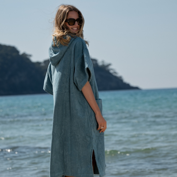 Femme souriante en poncho en coton biologique coloris bleu lagon - Atelier Dune