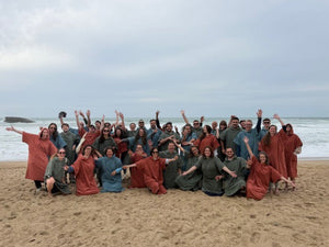 Cadeaux d'entreprise premium — équipe en séminaire portant des ponchos en coton biologique Atelier Dune