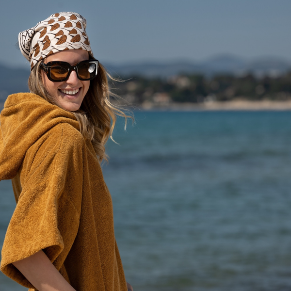 Femme au bord de la mer en poncho en coton biologique coloris caramel - Atelier Dune