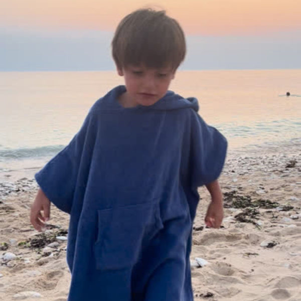 Petite garcon portant un poncho en coton biologique coloris outremer - Atelier Dune