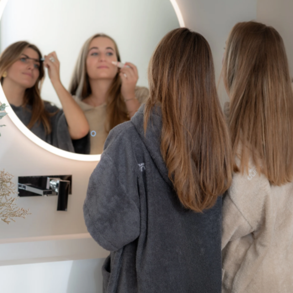 Deux femmes dans une salle de bain portant des ponchos bio sable et graphite - Atelier Dune