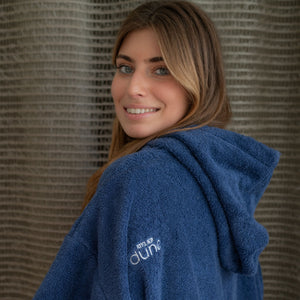 Femme souriante portant un poncho moelleux en coton bio outremer - Atelier Dune