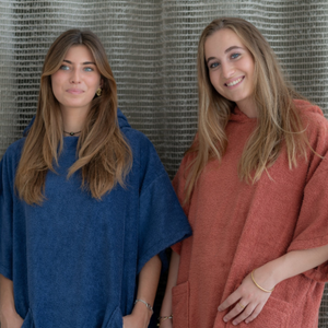 Duo de femme en intérieur portant un poncho en coton biologique outremer et terracotta - Atelier Dune