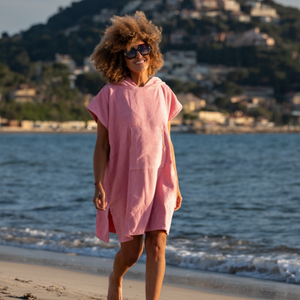 Femme a la plage portant un poncho leger en coton biologique coloris rose malabar - Atelier Dune