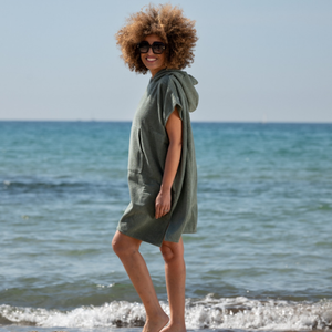 Femme a la plage portant un poncho leger en coton biologique coloris sauge - Atelier Dune