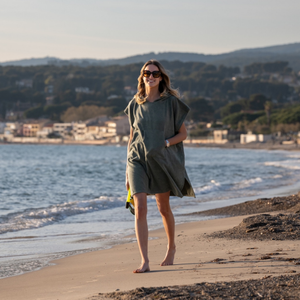 Femme a la plage portant un poncho leger en coton biologique coloris sauge - Atelier Dune