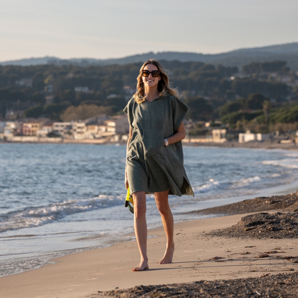 Femme a la plage portant un poncho leger en coton biologique coloris sauge - Atelier Dune