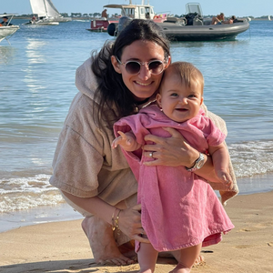 Une maman avec son bebe portant un poncho en coton biologique coloris rose malabar - Atelier Dune