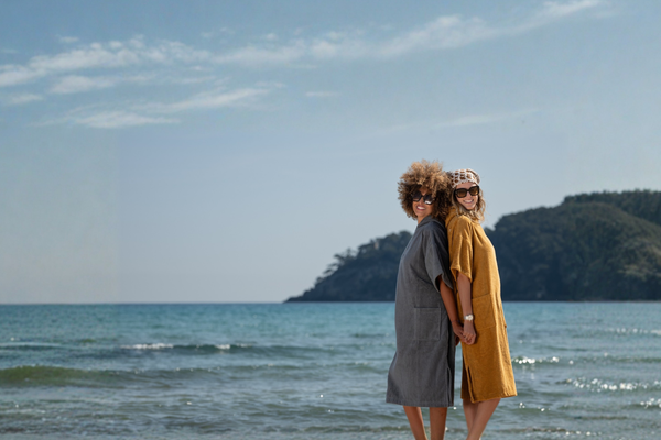 Femmes souriantes en poncho de bain pour la plage Atelier Dune Graphite et Caramel 
