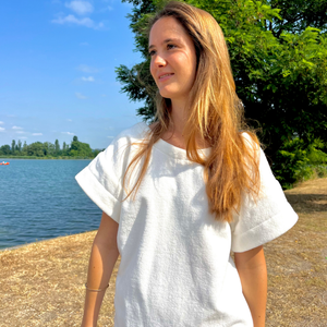 Femme portant une robe vintage courte en coton biologique coloris chantilly a la plage - Atelier Dune