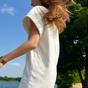 Femme portant une robe vintage courte en coton biologique coloris chantilly a la plage - Atelier Dune