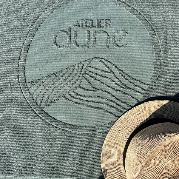 Zoom sur le logo de la serviette de plage en coton biologique sauge - Atelier Dune