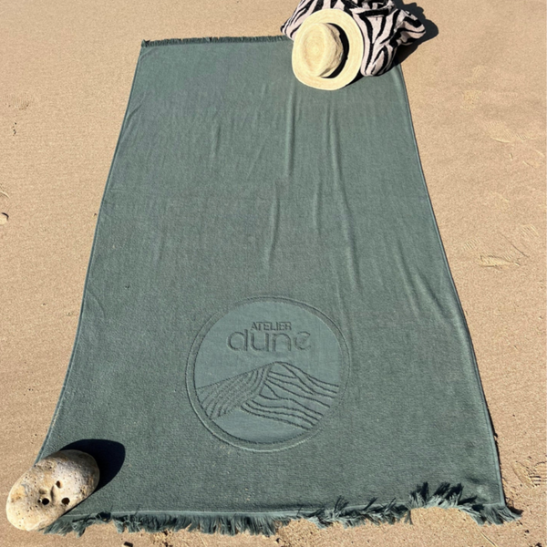 Serviette de plage double-face en coton biologique outremer sur le sable - Atelier Dune