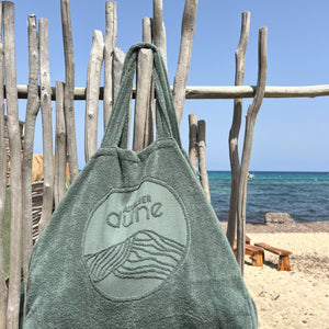 Maxi totebag en coton bio labels Gots et OekoTex avec gros logo en jaquard, grande contenance, coloris sauge, suspendu sur bois flotté à la plage - atelier dune